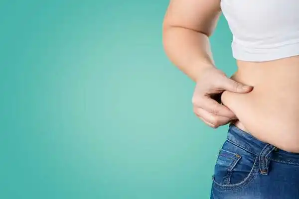 Image of woman pinching her love handles to show weight gain Portobello